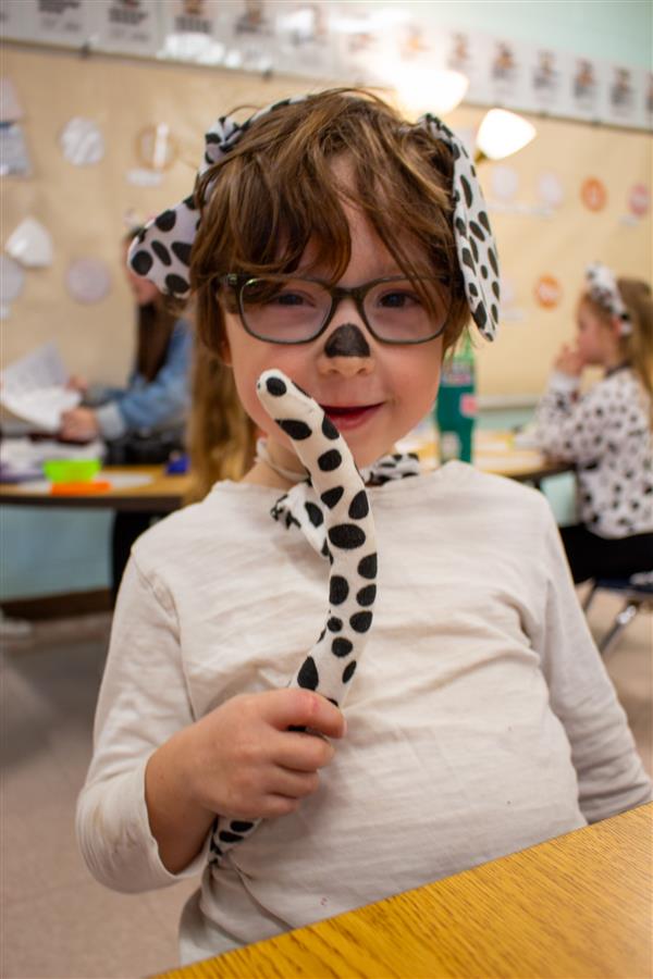 girl dressed as dalmatian dog holding tail